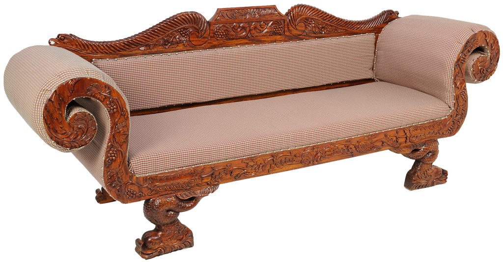 A CARVED DOLPHIN AND DRAGON THEMED ASIAN SOFA IN A: A CARVED DOLPHIN AND DRAGON THEMED ASIAN SOFA IN A WALNUT FINISH Early - Mid 20th Century Overall Condition: Very Good. Losses to carving with damage at foot, re-upholstry detected from tack holes, mi