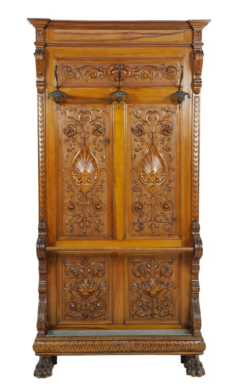 AN ITALIAN RENAISSANCE REVIVAL CARVED WALNUT HALL RACK: AN ITALIAN RENAISSANCE REVIVAL CARVED WALNUT HALL RACK Late 19th-Early 20th Century The walnut hall rack with carved palmette and scrolling tendril decoration, three coat hooks, umbrella bar, and two 