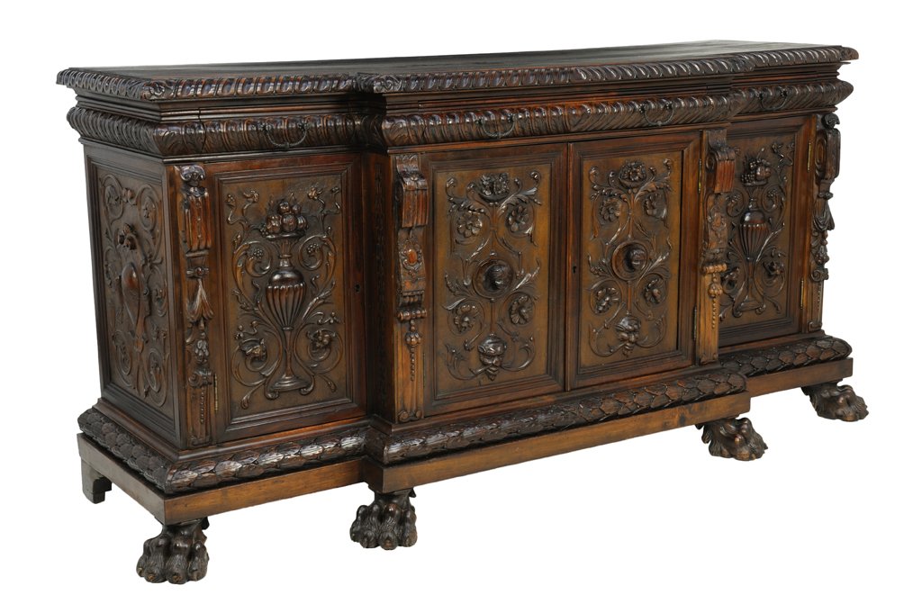 A RENAISSANCE REVIVAL CARVED WALNUT BUFFET: A RENAISSANCE REVIVAL CARVED WALNUT BUFFET Late 19th-Early 20th Century The Renaissance Revival buffet with four cabinets and stepped center, with carved petal and acanthus leaf edge, foliate and reli
