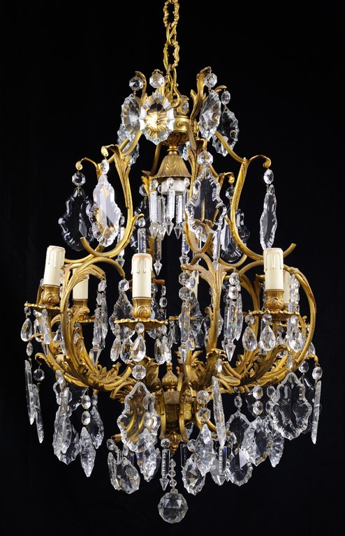 A GILT METAL AND CRYSTAL SIX-LIGHT CHANDELIER: A GILT METAL AND CRYSTAL SIX-LIGHT CHANDELIER Mid - Late 20th Century The six-light gilt metal chandelier with faceted oval, spear, pear shaped crystal lusters. Wear commensurate with age. Needs to be