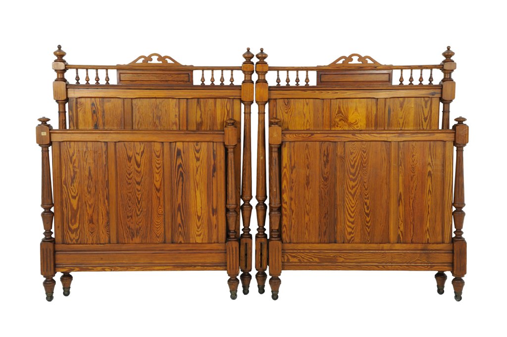 A PAIR OF FRENCH PROVINCIAL PINE BEDS: A PAIR OF FRENCH PROVINCIAL PINE BEDS Early 20th Century The pair of beds of panel construction with turned uprights raised on tapered legs, pierced crest rail with finial gallery to headboards. Overa