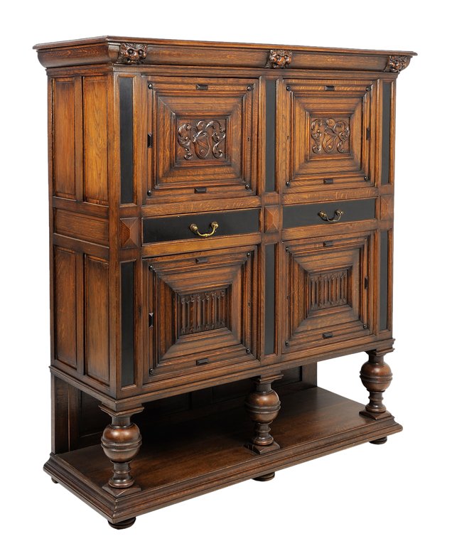 A FRENCH RENAISSANCE REVIVAL OAK CUPBOARD: A FRENCH RENAISSANCE REVIVAL OAK CUPBOARD The oak and ebonized wood cupboard with two doors with carved shield and helmet decoration over two drawers above two doors with linen-fold carving, turned cu