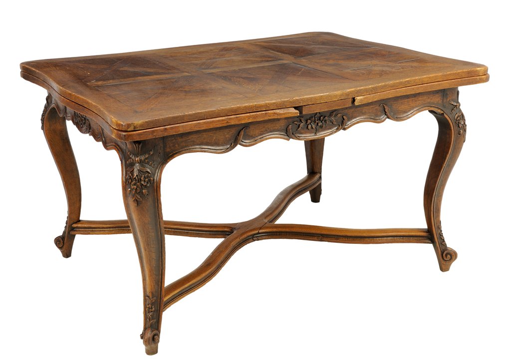 A FRENCH PROVINCIAL STYLE OAK DRAW-LEAF DINING TABLE: A FRENCH PROVINCIAL STYLE OAK DRAW-LEAF DINING TABLE The rectangular table with shaped apron with foliate decoration, each end with draw-leaf, raised on cabriole legs, joined by an X-form stretcher en
