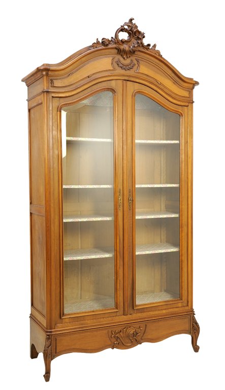 A FRENCH LOUIS XV STYLE WALNUT VITRINE CABINET: A FRENCH LOUIS XV STYLE WALNUT VITRINE CABINET The two door vitrine cabinet with shaped glazed doors, rocaille carved crest over the domed cornice, raised on scrolled legs. 100¼ x 52¼ x 21 inches.