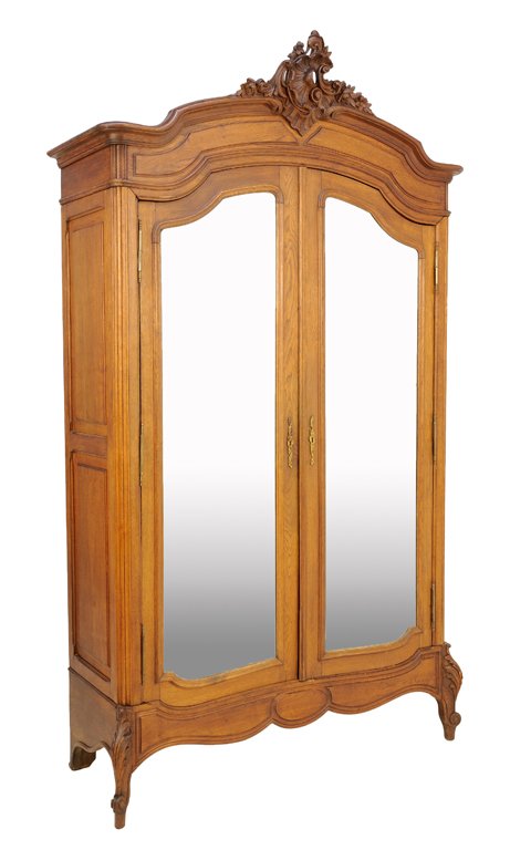 A FRENCH LOUIS XV STYLE WALNUT ARMOIRE: A FRENCH LOUIS XV STYLE WALNUT ARMOIRE The two door armoire fitted with shaped mirror plates, rocaille carved crest over the arched cornice, raised on scrolled legs. 95½ x 54½ x 22 inches.