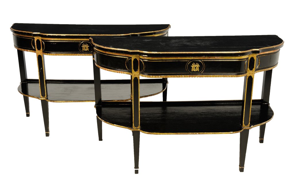 A PAIR OF FRENCH DIRECTOIRE STYLE EBONIZED CONSOLE: A PAIR OF FRENCH DIRECTOIRE STYLE EBONIZED CONSOLE TABLES The D-shaped tables with gilt banding over conforming frieze centered by ribbon-tied escutcheon, raised on tapering legs ending in spade feet.