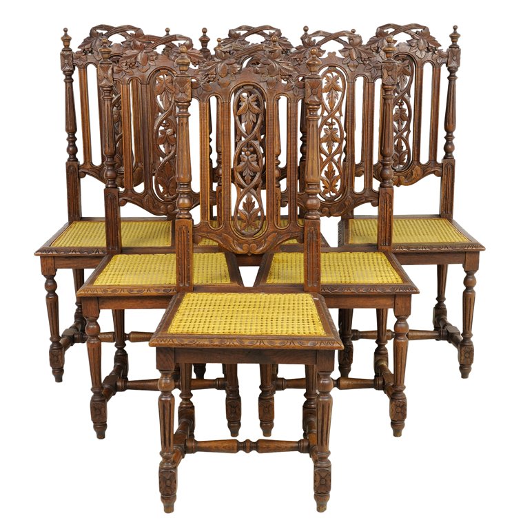 A SET OF SIX RENAISSANCE REVIVAL OAK SIDE CHAIRS: A SET OF SIX RENAISSANCE REVIVAL OAK SIDE CHAIRS Each having a leaf form crest flanked by turned finials over vertical and pierce carved back splats above caned trapezoidal seat, raised on turned legs