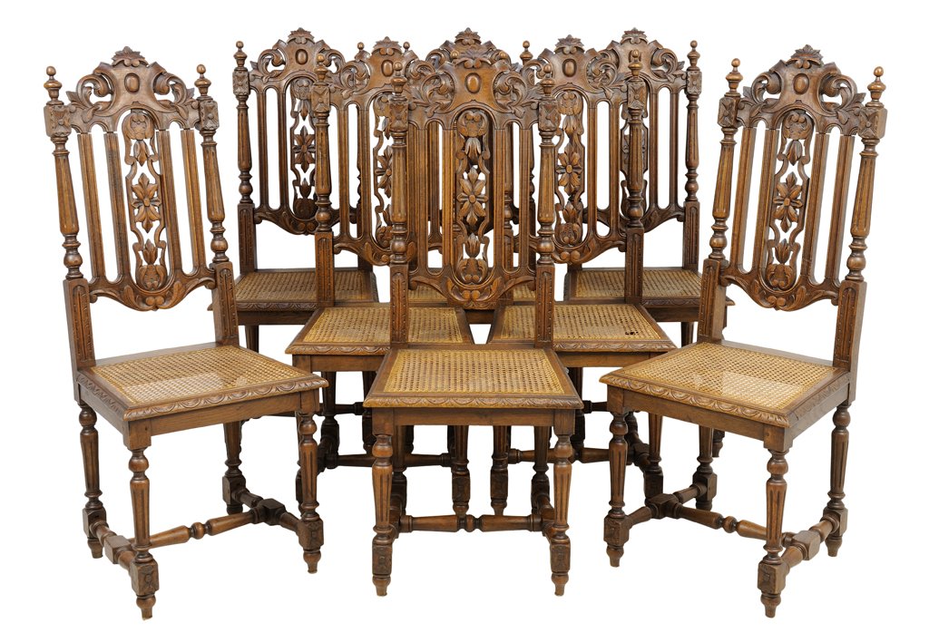 A SET OF EIGHT RENAISSANCE REVIVAL OAK SIDE CHAIRS: A SET OF EIGHT RENAISSANCE REVIVAL OAK SIDE CHAIRS Each having a leaf form crest flanked by turned finials over vertical and pierce carved back splats above caned trapezoidal seat, raised on turned an