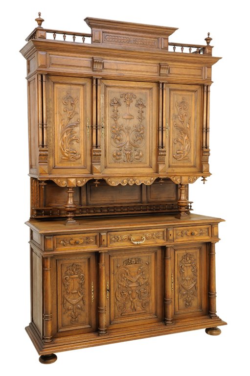 A RENAISSANCE REVIVAL WALNUT BUFFET A DEUX CORPS: A RENAISSANCE REVIVAL WALNUT BUFFET A DEUX CORPS The supertstructure having a central flared cornice flanked by a galleried border and two urn form finials over three paneled doors with scrolling foli