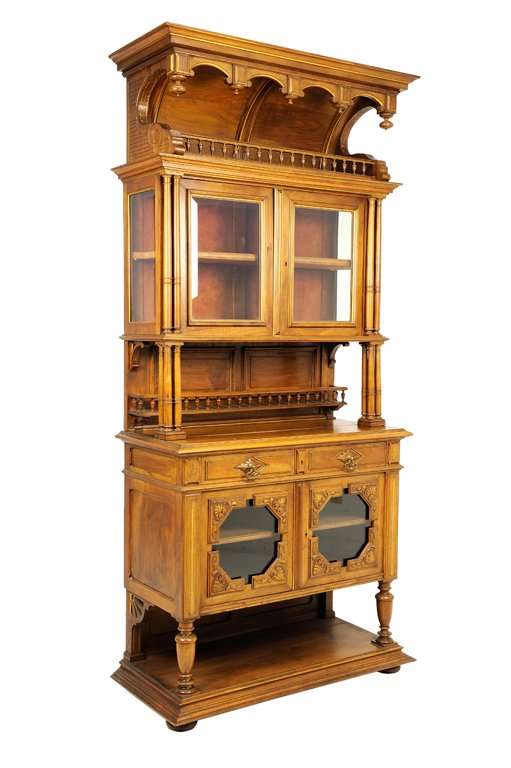 A GOTHIC REVIVAL WALNUT BUFFET A DEUX CORPS: A GOTHIC REVIVAL WALNUT BUFFET A DEUX CORPS The superstructure having a flared cornice over the barrel vault canopy above two glazed doors, raised on quadripartite columnar supports over the rectangul