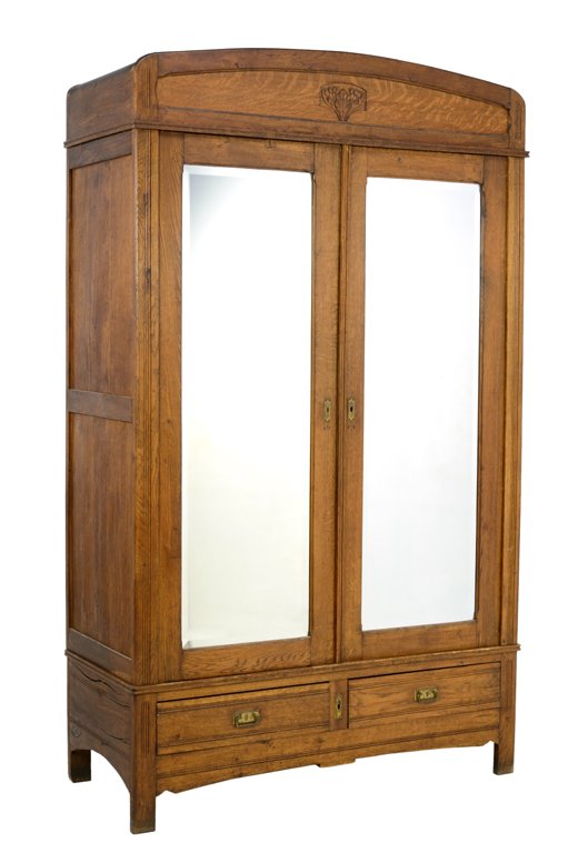 AN ARTS & CRAFTS STYLE OAK WARDROBE: AN ARTS & CRAFTS STYLE OAK WARDROBE Early-Mid 20th Century The wardrobe having a curved cornice over the plain frieze centered with carved leaf decoration above two doors each fit with a mirror plate 