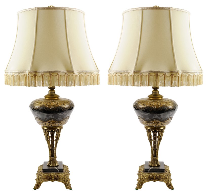 A PAIR OF NEOCLASSICAL STYLE GILT METAL MOUNTED GLASS: A PAIR OF NEOCLASSICAL STYLE GILT METAL MOUNTED GLASS TABLE LAMPS The pair each having a gilt and enamel painted glass body above a pierced gilt metal standard on a black marble base, the whole raised