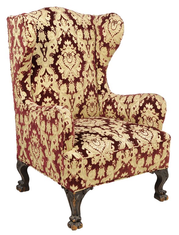 A CHIPPENDALE STYLE UPHOLSTERED WINGBACK ARMCHAIR: A CHIPPENDALE STYLE UPHOLSTERED WINGBACK ARMCHAIR Having a curved crest rail over the upholstered back and seat, raised on short cabriole legs ending in lobed feet. 44¾ x 28½ x 30½ inches