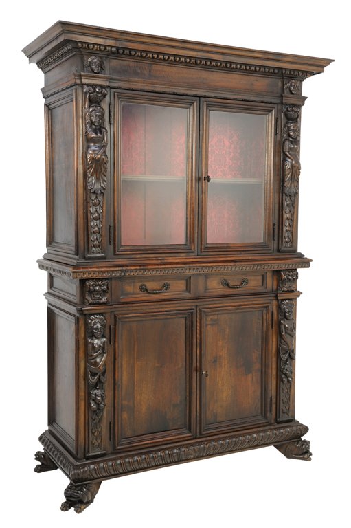AN ITALIAN RENAISSANCE REVIVAL WALNUT ARMOIRE: AN ITALIAN RENAISSANCE REVIVAL WALNUT ARMOIRE The armoire with two glazed doors above two drawers and two panel doors each flanked by carved caryatid figures, crowned by stepped flared cornice with de
