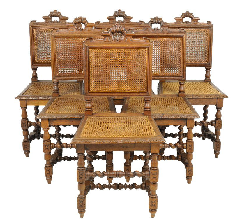 A SET OF SIX RENAISSANCE REVIVAL OAK SIDE CHAIRS: A SET OF SIX RENAISSANCE REVIVAL OAK SIDE CHAIRS Each chair having a carved crest rail over the caned back and seat, raised on shaped legs, joined by a series of barley twist stretchers, ending in tou