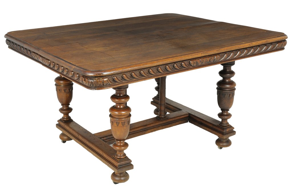A RENAISSANCE REVIVAL OAK DINING TABLE: A RENAISSANCE REVIVAL OAK DINING TABLE The rectangular top having rounded corners above the molded frieze, raised on baluster form supports, joined by an H-form stretcher, ending in flattened ball fee