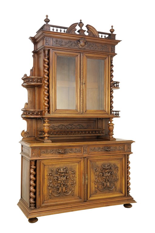A RENAISSANCE REVIVAL WALNUT BUFFET A DEUX CORPS: A RENAISSANCE REVIVAL WALNUT BUFFET A DEUX CORPS The buffet having a broken arch pediment centered with a finial, galleried cornice flanked by urn form finials above two glazed doors flanked by barley
