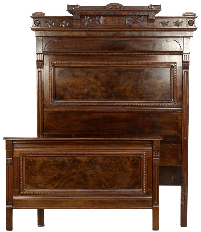 AN EASTLAKE STYLE MAHOGANY BED: AN EASTLAKE STYLE MAHOGANY BED The headboard having a stepped cornice with carved geometric decoration, the headboard and footboard each having a central burled panel flanked by engaged fluted columns
