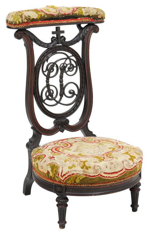 A FRENCH EBONIZED PRIE DIEU: A FRENCH EBONIZED PRIE DIEU The prie dieu having an upholstered crest rail, above the shield form back, over the circular needlepoint seat, raised on tapering cylindrical fore legs. H 34¾ x W 18¾ x