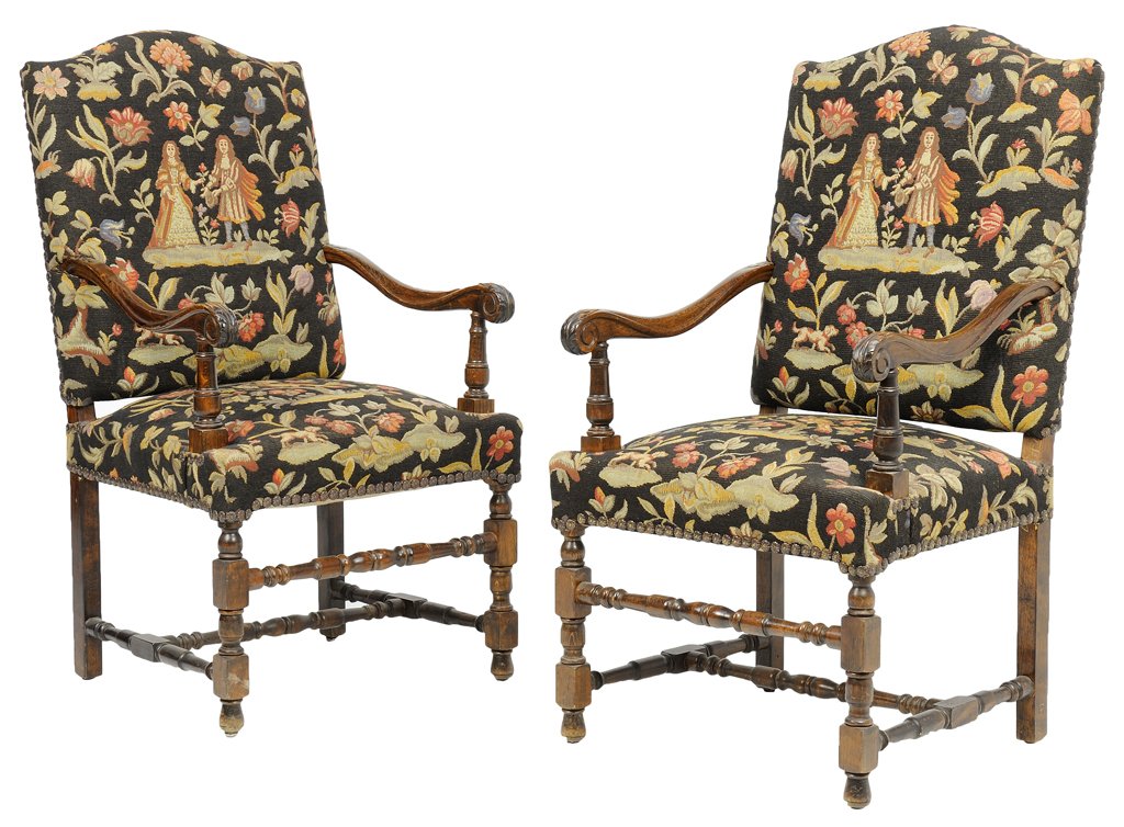 A PAIR OF FRENCH LOUIS XIII STYLE HALL CHAIRS: A PAIR OF FRENCH LOUIS XIII STYLE HALL CHAIRS Each chair having a curved crest rail over the needlepoint back and seat with nailhead border, within open scrolling arms, raised on shaped legs, joined b