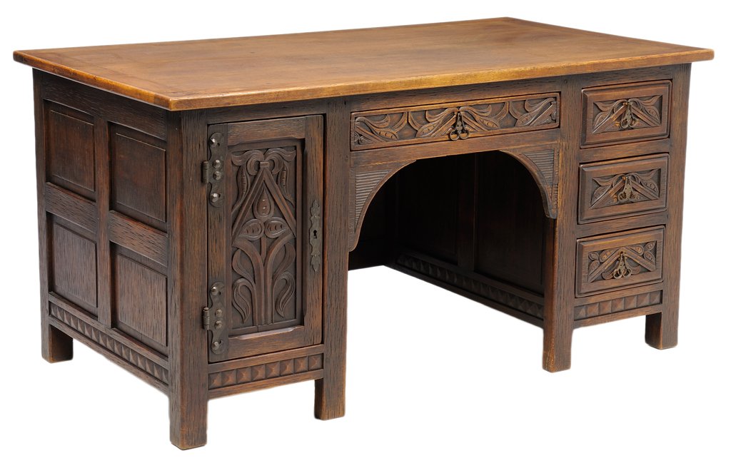 A FRENCH PROVINCIAL STYLE DESK: A FRENCH PROVINCIAL STYLE DESK The writing desk having a rectangular top over a central drawer flanked by a paneled door and a column of three drawers each with carved scroll decoration, coffer panele