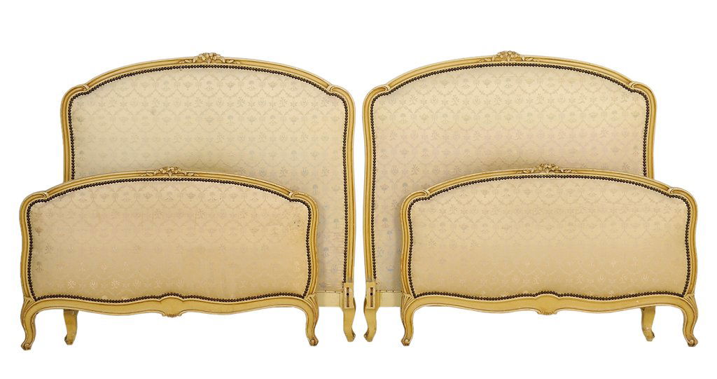 A PAIR OF FRENCH LOUIS XV STYLE PAINTED AND UPHOLSTERED: A PAIR OF FRENCH LOUIS XV STYLE PAINTED AND UPHOLSTERED BEDS Each bed having a curved top rail with foliate crest over the upholstered panel, raised on short cabriole legs. Comprises headboard, footbo