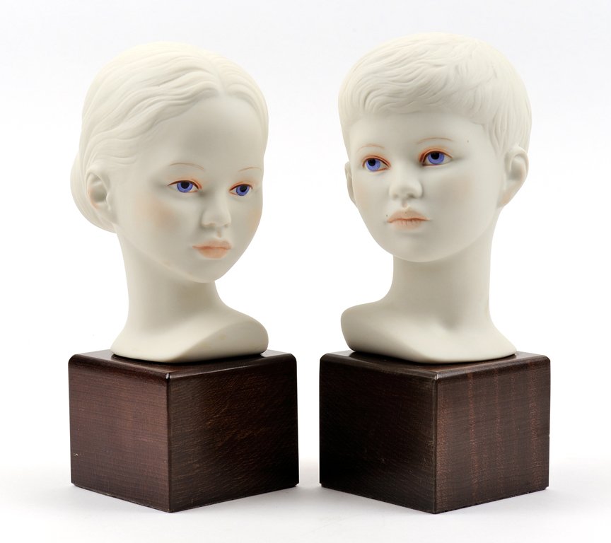 TWO CYBIS PORCELAIN BUSTS: TWO CYBIS PORCELAIN BUSTS Depicting a young boy and a young girl, each raised on affixed wood plinth, signed "Cybis" to reverse. H 9½ x W 4 x D 4¾ inches.