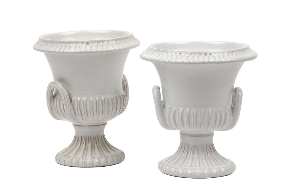 A PAIR OF ITALIAN CERAMIC FAIENCE JARDINIERES: A PAIR OF ITALIAN CERAMIC FAIENCE JARDINIERES Each of typical handled urn form in a white faience glaze, and marked to base Made in Italy 1992. H 5½ x W 4¾ x D 4¾ inches.