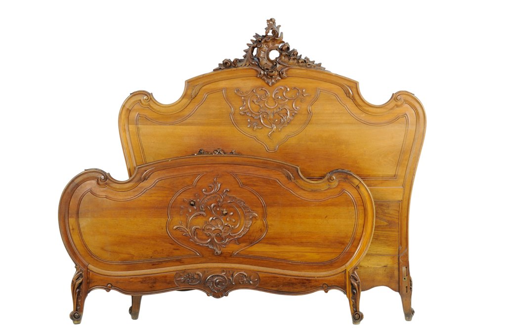 A FRENCH LOUIS XV STYLE BED: A FRENCH LOUIS XV STYLE BED The headboard having a carved acanthus leaf crest over the serpentine top rail. Each having carved foliate decoration to the back panel, raised on scrolled toes. Comprising