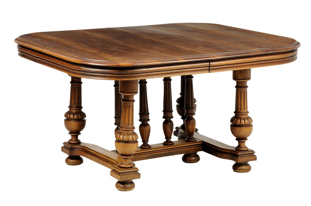 A RENAISSANCE REVIVAL WALNUT DINING TABLE: A RENAISSANCE REVIVAL WALNUT DINING TABLE The table having a rectangular top with rounded corners over the conforming frieze, raised on baluster form legs, joined by H-form stretcher centered with a s