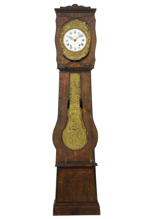 A FRENCH MORBIER STYLE TALL CASE CLOCK: A FRENCH MORBIER STYLE TALL CASE CLOCK The tall case clock having a shaped pediment over the circular enameled dial with Roman numeral hours within a pressed gilt metal border, the case with carved fo
