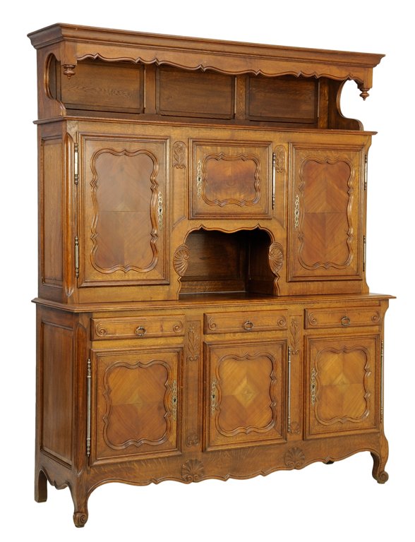 A FRENCH PROVINCIAL STYLE BUFFET A DEUX CORPS: A FRENCH PROVINCIAL STYLE BUFFET A DEUX CORPS The buffet a deux corps having a flared pediment over a rectangular top above three paneled doors over a rectangular top and conforming case fitted with t