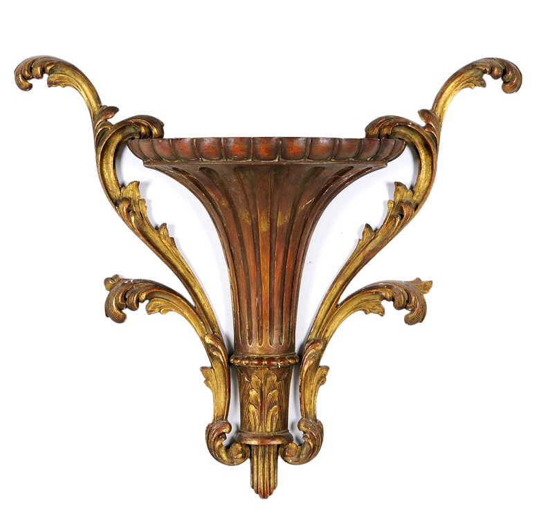A FRENCH NEOCLASSICAL STYLE GILTWOOD WALL BRACKET SHELF: A FRENCH NEOCLASSICAL STYLE GILTWOOD WALL BRACKET SHELF Of reeded columnar form, flanked at each side by rocaille embellishment. H 22 x W 25 x D 6¼ inches.