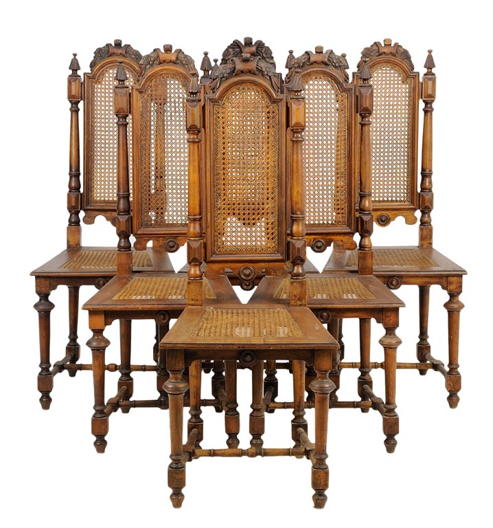 A SET OF SIX RENAISSANCE REVIVAL DINING CHAIRS: A SET OF SIX RENAISSANCE REVIVAL DINING CHAIRS The dining chairs each having a foliate carved crest over the domed top rail above the caned back and seat, raised on cylindrical legs, joined by H-form
