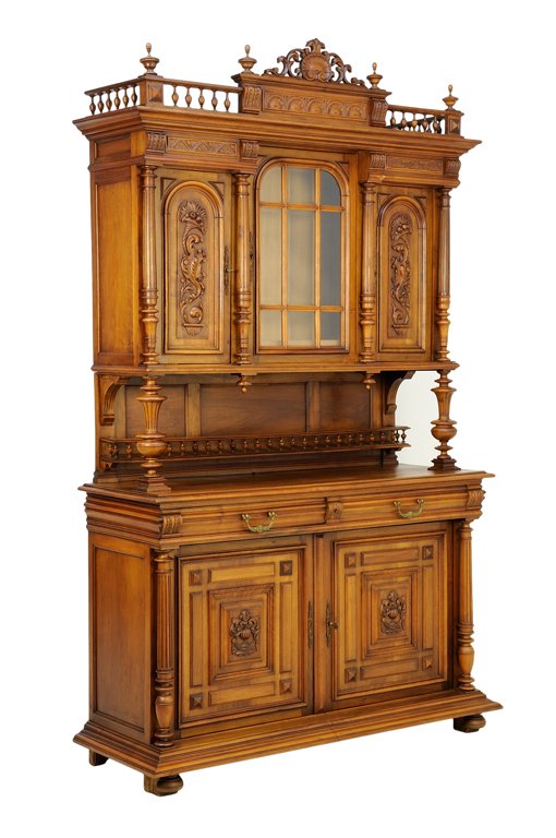 A RENAISSANCE REVIVAL WALNUT BUFFET A DEUX CORPS: A RENAISSANCE REVIVAL WALNUT BUFFET A DEUX CORPS The buffet a deux corps having a flared cornice surmounted with a shell carved crest, flanked by urn form finials and a three-quarter spindled gallery,