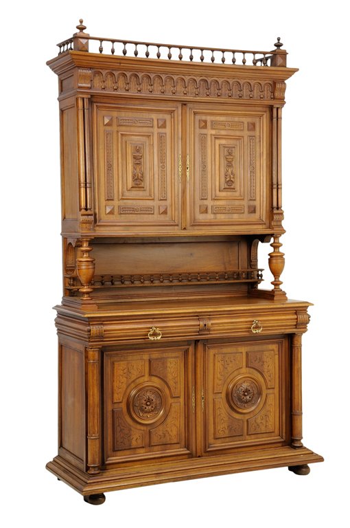 A RENAISSANCE REVIVAL WALNUT BUFFET A DEUX CORPS: A RENAISSANCE REVIVAL WALNUT BUFFET A DEUX CORPS The buffet a deux corps having a flared cornice surmounted with a three-quarter gallery and urn form finials over the carved frieze above two paneled d