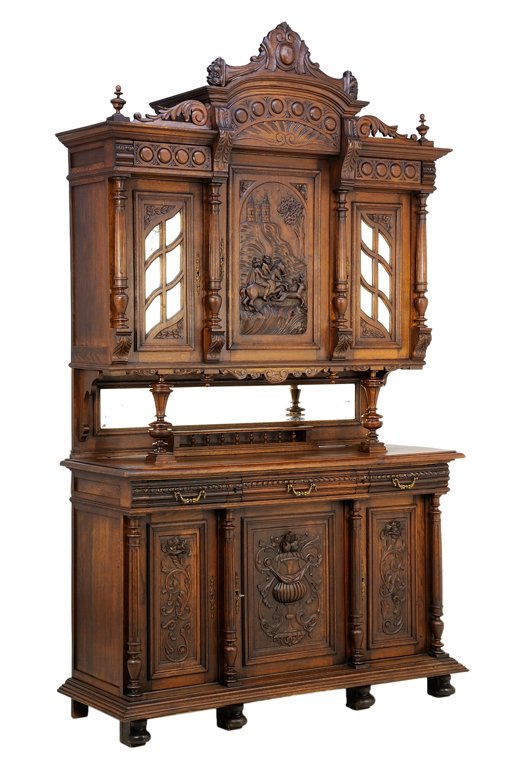 A RENAISSANCE REVIVAL BUFFET A DEUX CORPS: A RENAISSANCE REVIVAL BUFFET A DEUX CORPS The buffet a deux corps having a stepped cornice surmounted with a shield carved crest, above a roundel carved frieze, over a central paneled door, flanked by