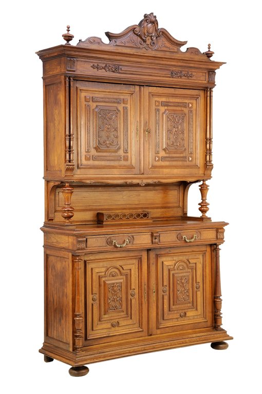 A RENAISSANCE REVIVAL BUFFET A DEUX CORPS: A RENAISSANCE REVIVAL BUFFET A DEUX CORPS The buffet a deux corps having a flared cornice surmounted with a shield carved crest flanked by urn form finials, above a foliate carved frieze and two panel