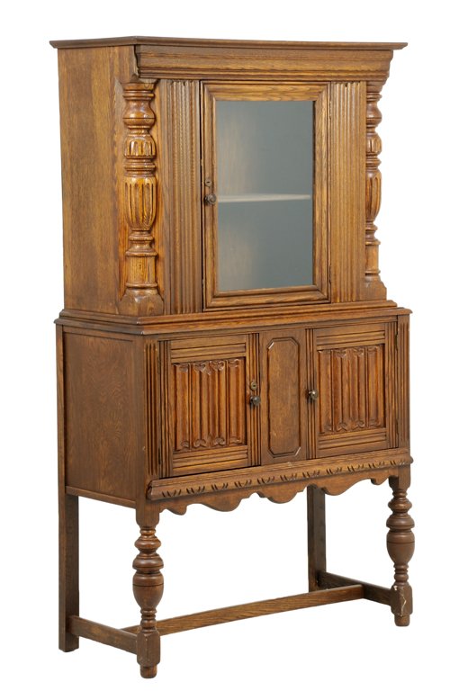 A RENAISSANCE REVIVAL CABINET ON STAND: A RENAISSANCE REVIVAL CABINET ON STAND The cabinet having a flared cornice over a single glazed door, opening to a shelved interior, flanked by engaged reeded columns, over two paneled doors, carved w