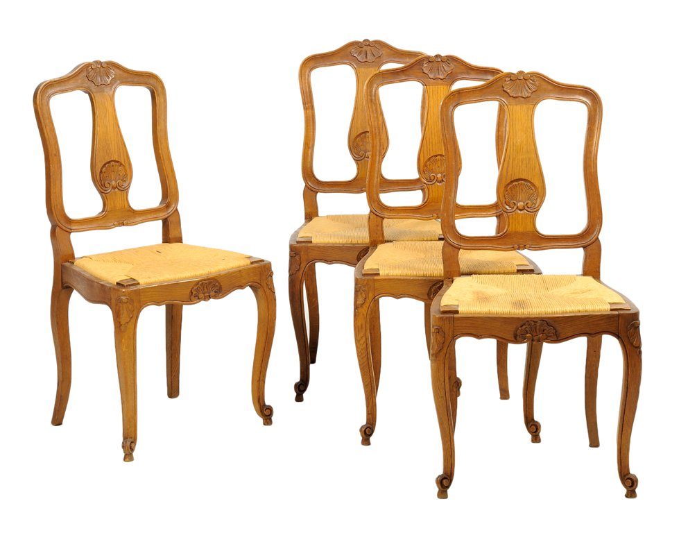 A SET OF FOUR FRENCH PROVINCIAL STYLE OAK CHAIRS: A SET OF FOUR FRENCH PROVINCIAL STYLE OAK CHAIRS Each chair having a shaped crest rail centered with a carved shell over the vasiform backsplat, above the trapezoidal rush seat, raised on slight cabri