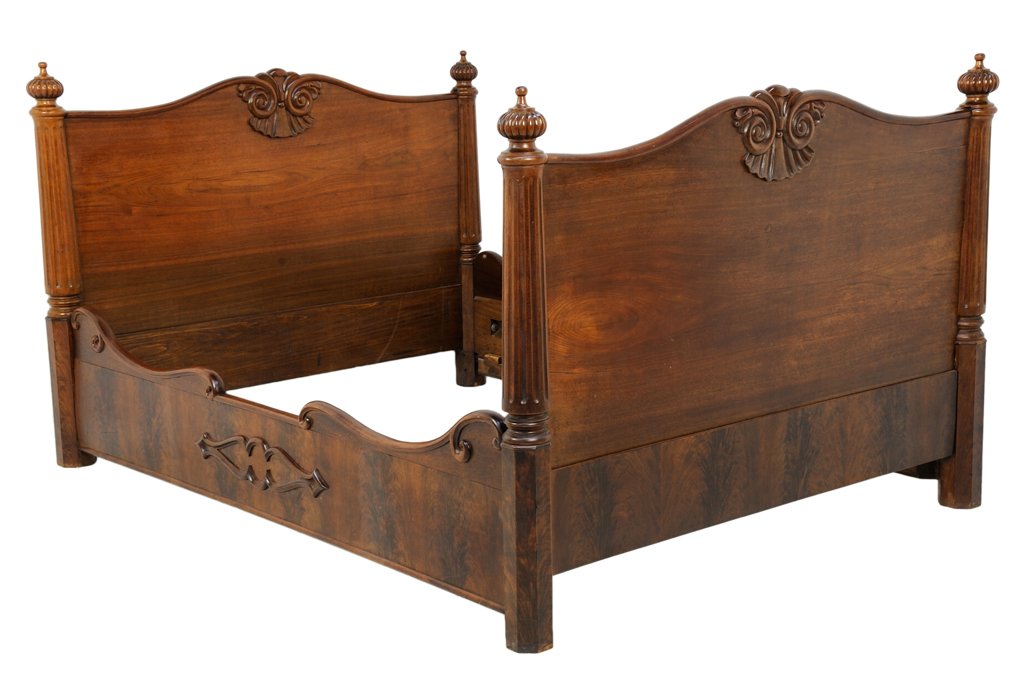 A FRENCH PROVINCIAL STYLE MAHOGANY BED: A FRENCH PROVINCIAL STYLE MAHOGANY BED The bed having a curved top rail centered with carved scroll decoration, flanked by urn form finials and engaged reeded tapering columns. Comprising headboard, f