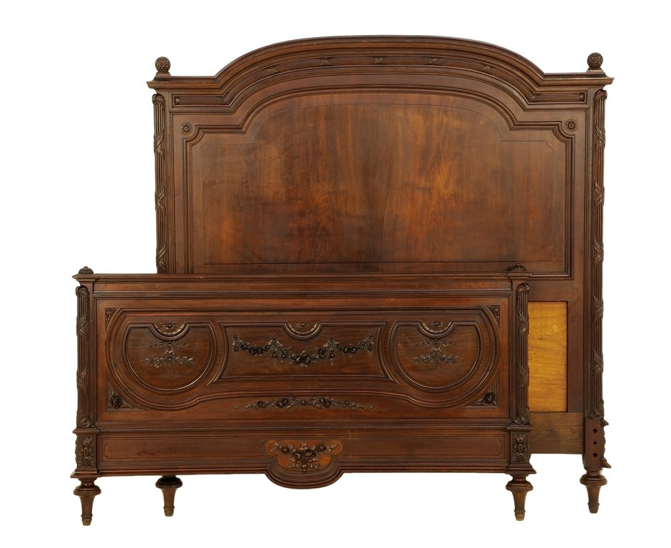 A FRENCH LOUIS XVI STYLE BED: A FRENCH LOUIS XVI STYLE BED The bed having a curved top rail flanked by ovoid form finials. The footboard having carved foliate decoration, each raised on toupie feet. Comprising headboard, footboard