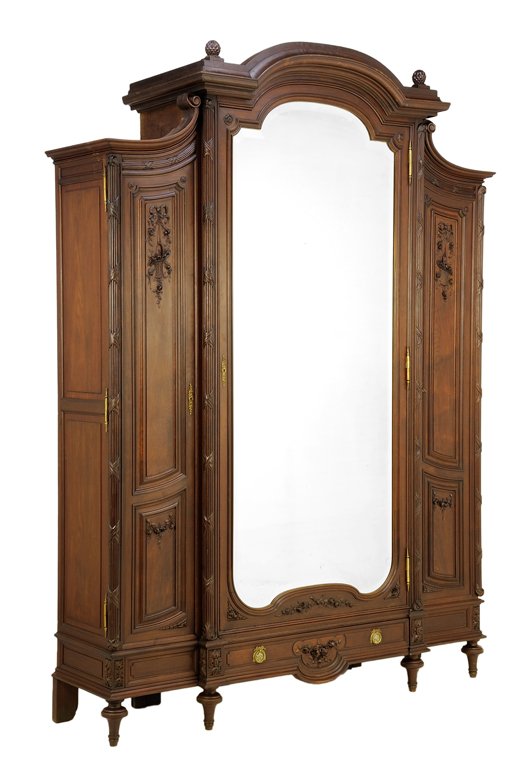 A FRENCH LOUIS XVI STYLE ARMOIRE: A FRENCH LOUIS XVI STYLE ARMOIRE The armoire having a domed cornice set with ovoid finials over a central mirror plate inset door, flanked by paneled doors with carved foliate decoration, above a sing