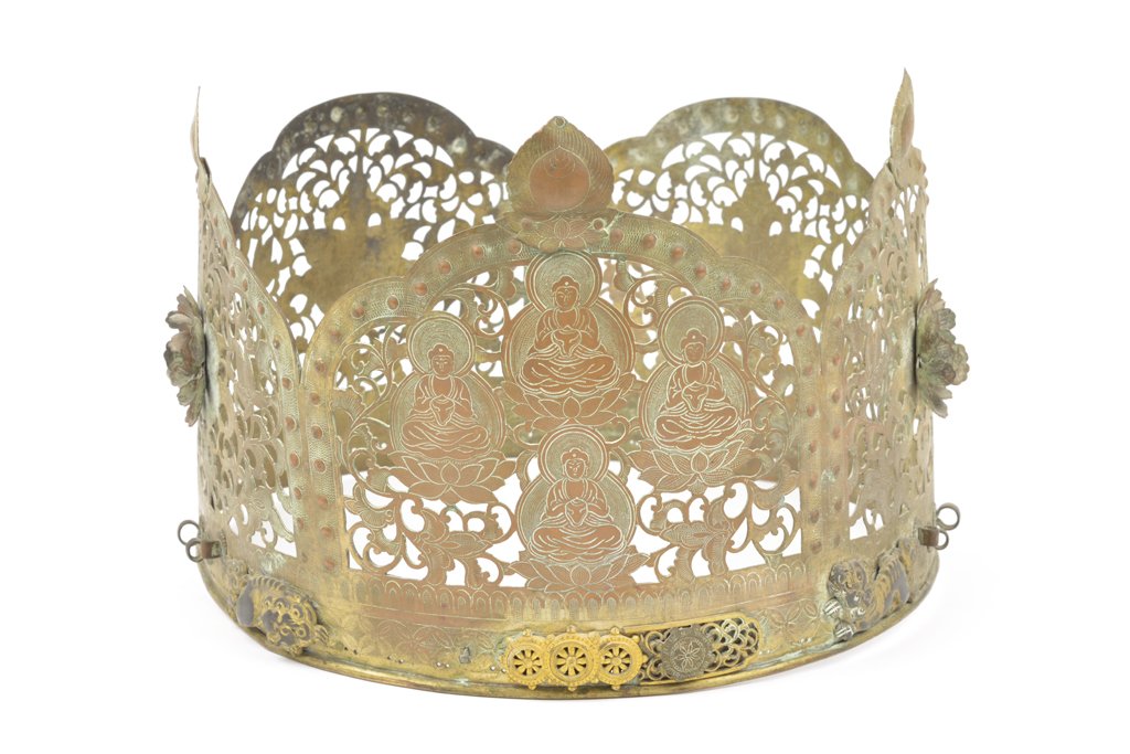 A TIBETAN GILT COPPER ALLOY CROWN: A TIBETAN GILT COPPER ALLOY CROWN Having pierced foliate decoration throughout, and having applied floral embellishments to each side, the front panel centering four seated Buddhist figures on lotus f