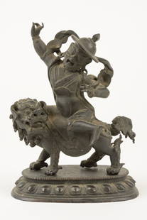 A SINO-TIBETAN BRONZE VAISRAVANA: A SINO-TIBETAN BRONZE VAISRAVANA Qing Dynasty The bronze figure depicting the guardian deity Vaisravana with upraised arms, seated on a snow lion and raised on a lotus form plinth. H 6¾ x W 5¼ x D 3