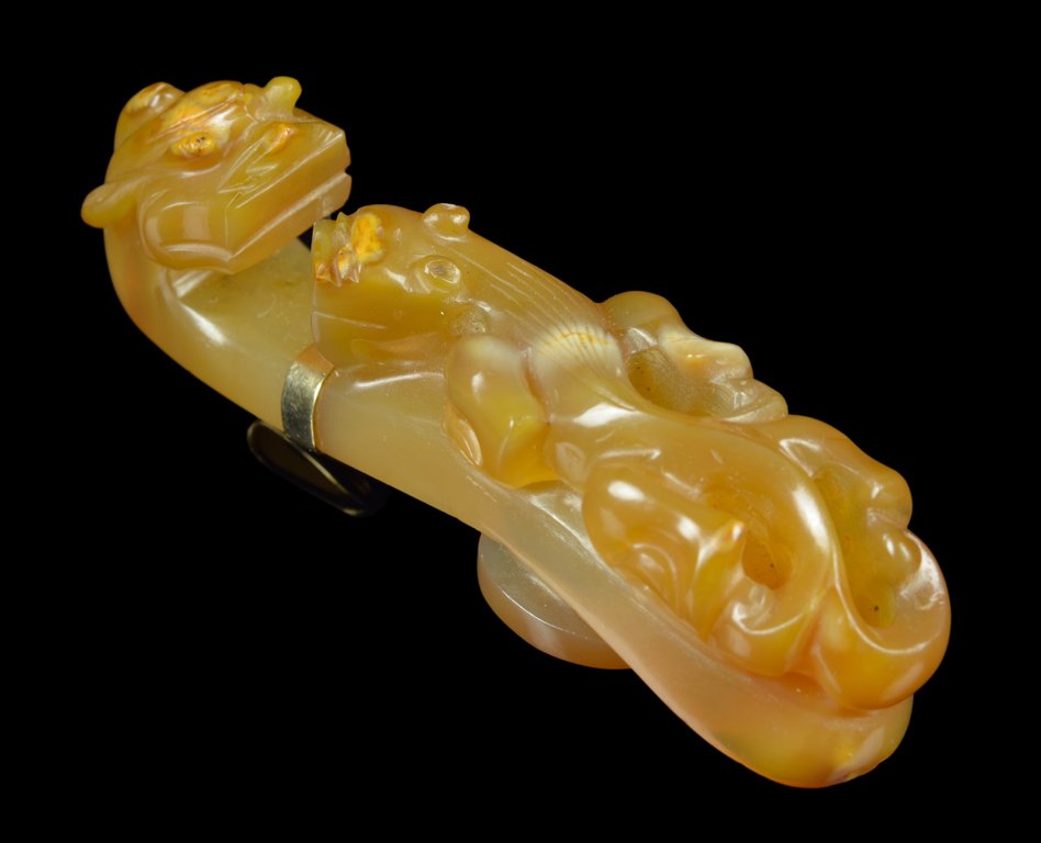 A CHINESE CARNELIAN BELT BUCKLE: A CHINESE CARNELIAN BELT BUCKLE Qing Dynasty The carved carnelian belt buckle modeled as two qilin, mounted in a gold pendant setting, the reverse marked 14K to one side. H 3 x W ¾ x D 1 inches.