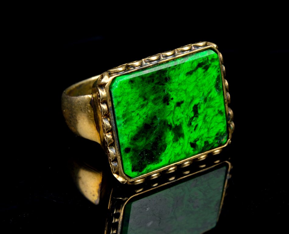 A BURMESE JADE AND STERLING SILVER RING Size 7: A BURMESE JADE AND STERLING SILVER RING The sterling silver ring by Irwan Holmes (American/Indonesian, 1942-2014), having burmese jade bezel-set above the ruyi form border, the shank marked 925 to int
