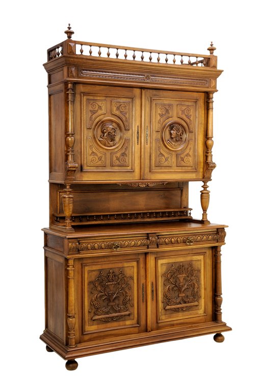 A RENAISSANCE REVIVAL BUFFET A DEUX CORPS: A RENAISSANCE REVIVAL BUFFET A DEUX CORPS The buffet a deux corps having a flared cornice surmounted with a three-quarter gallery and urn form finials over the carved frieze above two paneled doors wi
