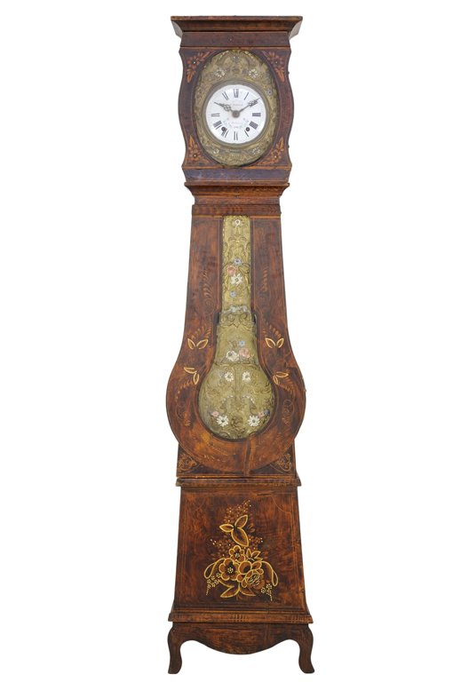 A FRENCH MORBIER STYLE TALL CASE CLOCK: A FRENCH MORBIER STYLE TALL CASE CLOCK The tall case clock having a flared pediment over the glazed door, opening to reveal the circular painted metal dial, set within a pressed gilt metal frame, abov