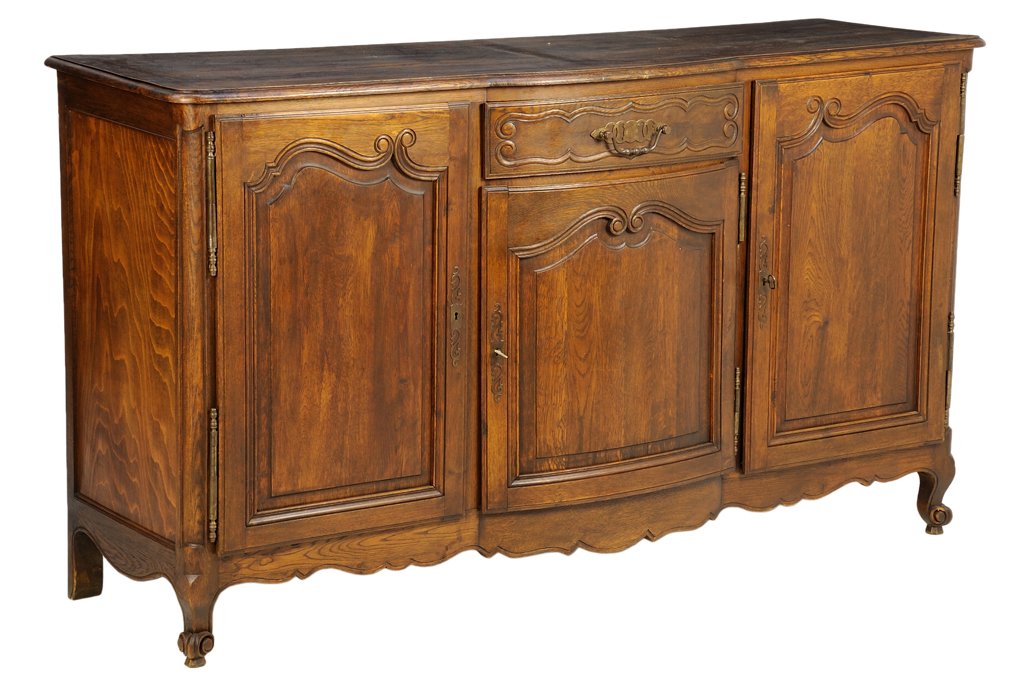 A FRENCH LOUIS XV STYLE SIDEBOARD: A FRENCH LOUIS XV STYLE SIDEBOARD The rectangular top with rounded corners, above a central short drawer with a multi-ring mount and bail handle, over three paneled doors with scrolled banding and ver